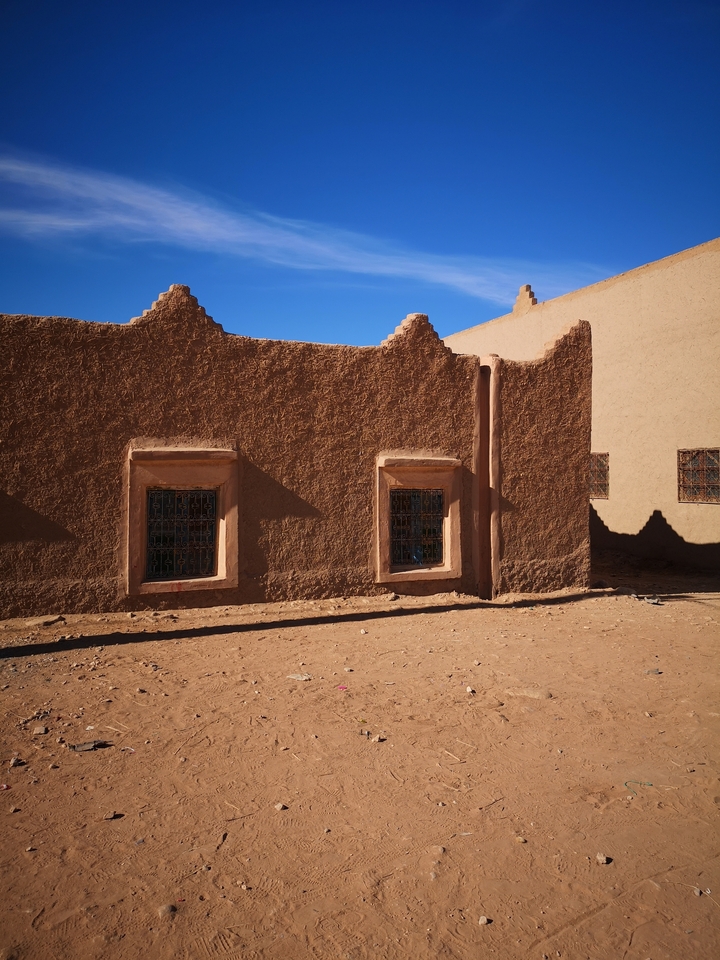 Traditional buildings made of mud bricks with decorative windows.