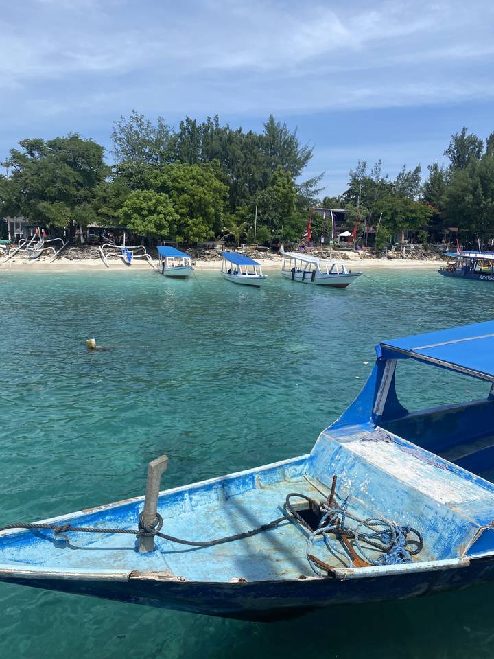 A beach with boats and a clear blue sky.