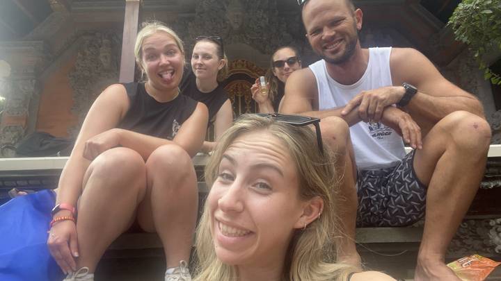 Group posing together with a carved stone backdrop.