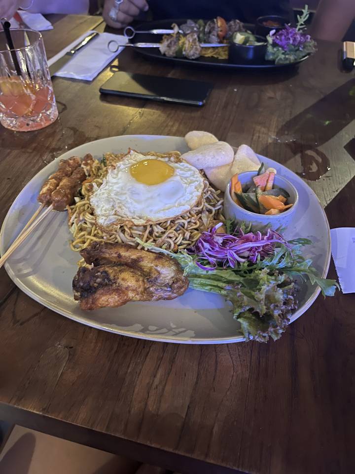 Plate of gourmet food with chicken, vegetables, and a fried egg.