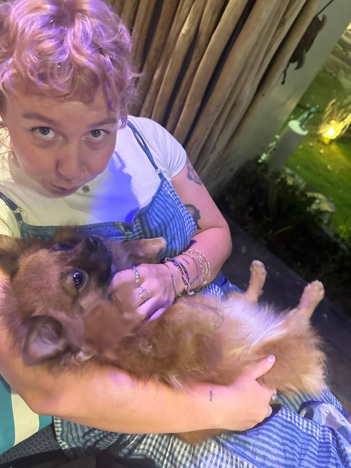 Person holding a dog indoors.