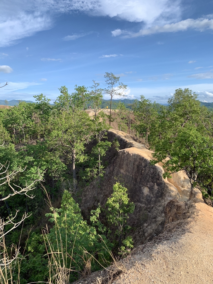 A narrow path through lush green cliffs.