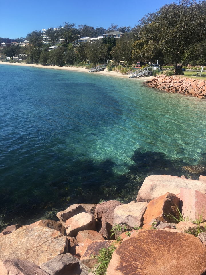 Clear blue water with rocks under the surface.