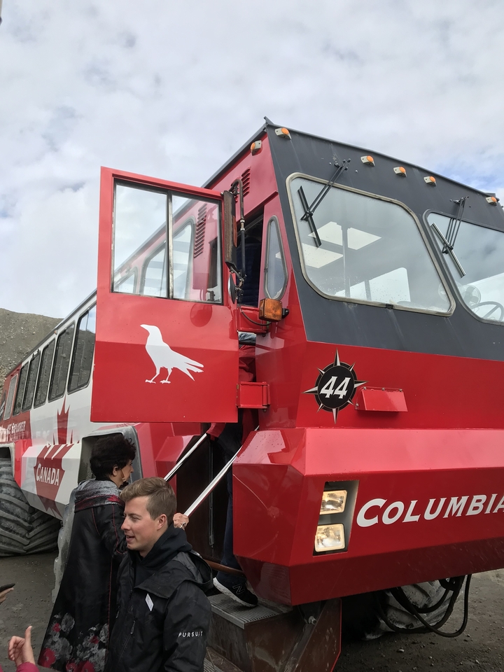Transport vehicle with open door, parked in a mountainous area.