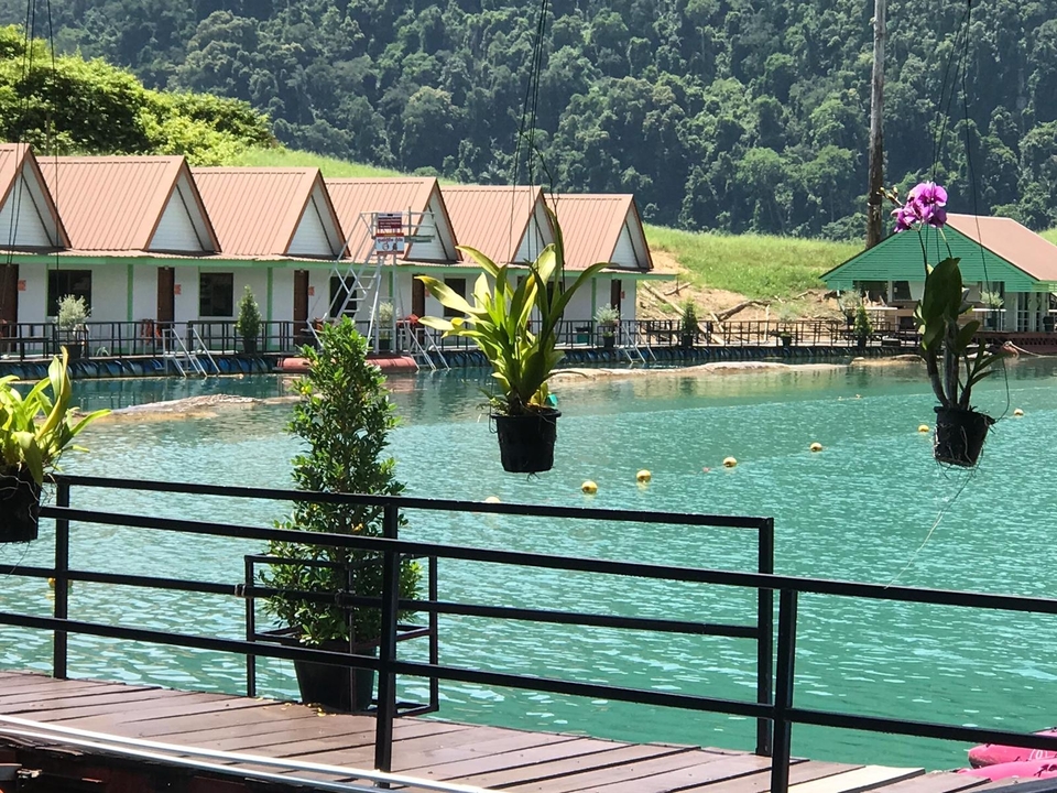 Scenic view of floating accommodations on a lake with greenery around.