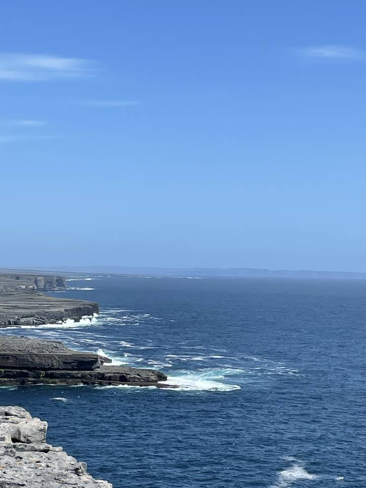 Side view of a rocky coastline with waves crashing against the rocks