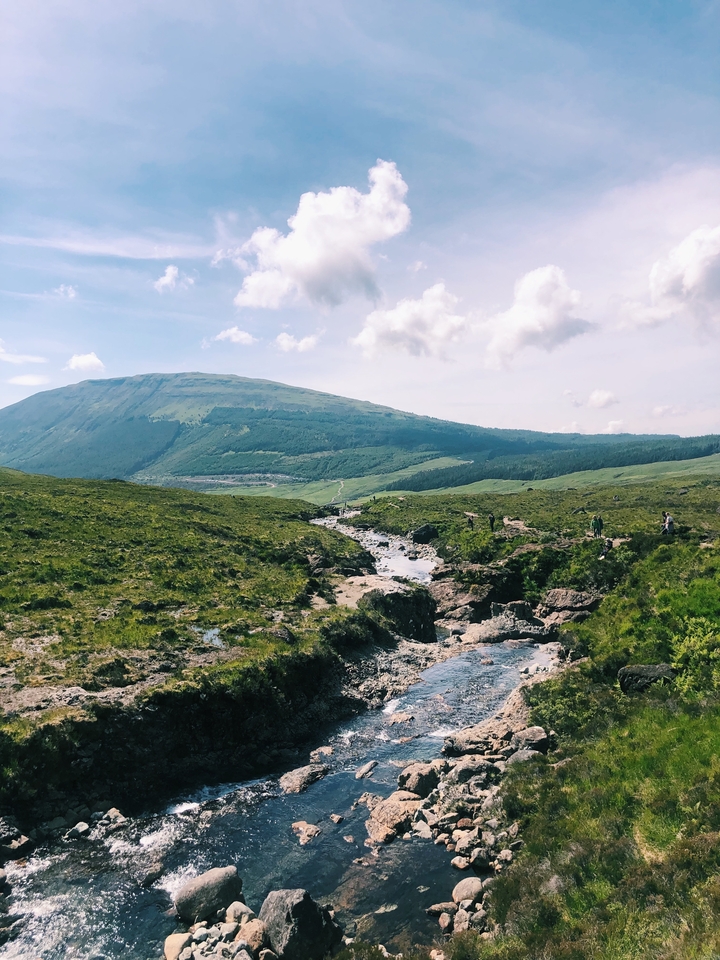 Landscape with people hiking on a rocky trail.