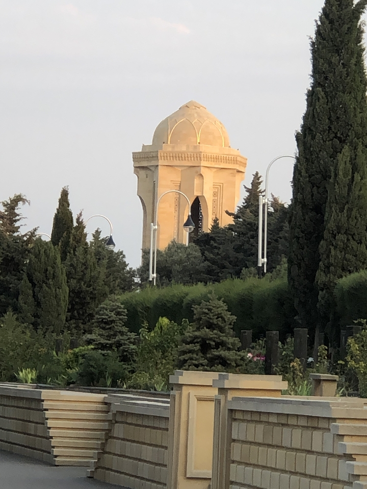 Towers behind trees in a lush garden area.