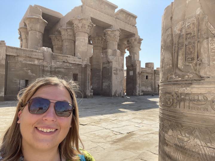 Person partially in view with columns of Kom Ombo Temple.