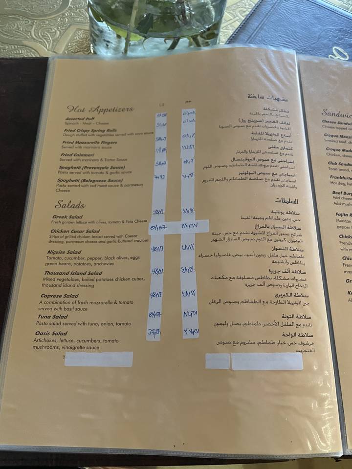 Restaurant menu with items listed in English and Arabic.