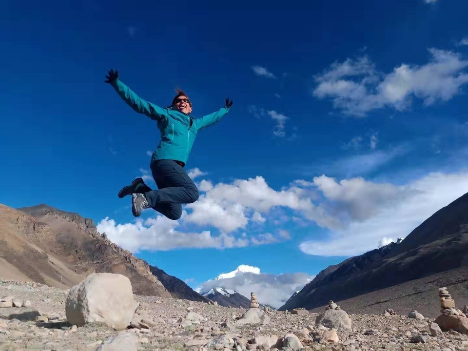 Personne sautant joyeusement dans un paysage montagneux.