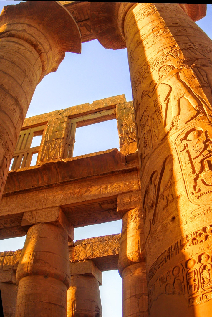 Ancient temple pillars with sunlight casting shadows.