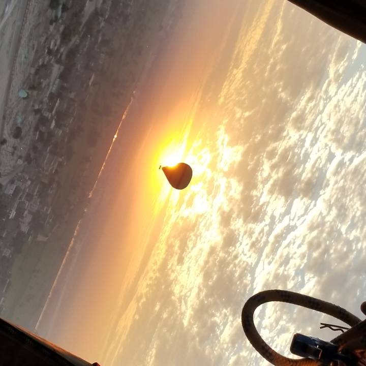 A hot air balloon at sunrise with a scenic view.