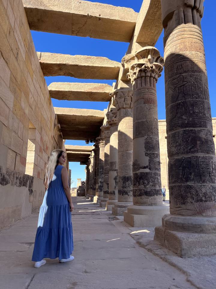 Person posing between ancient columns.