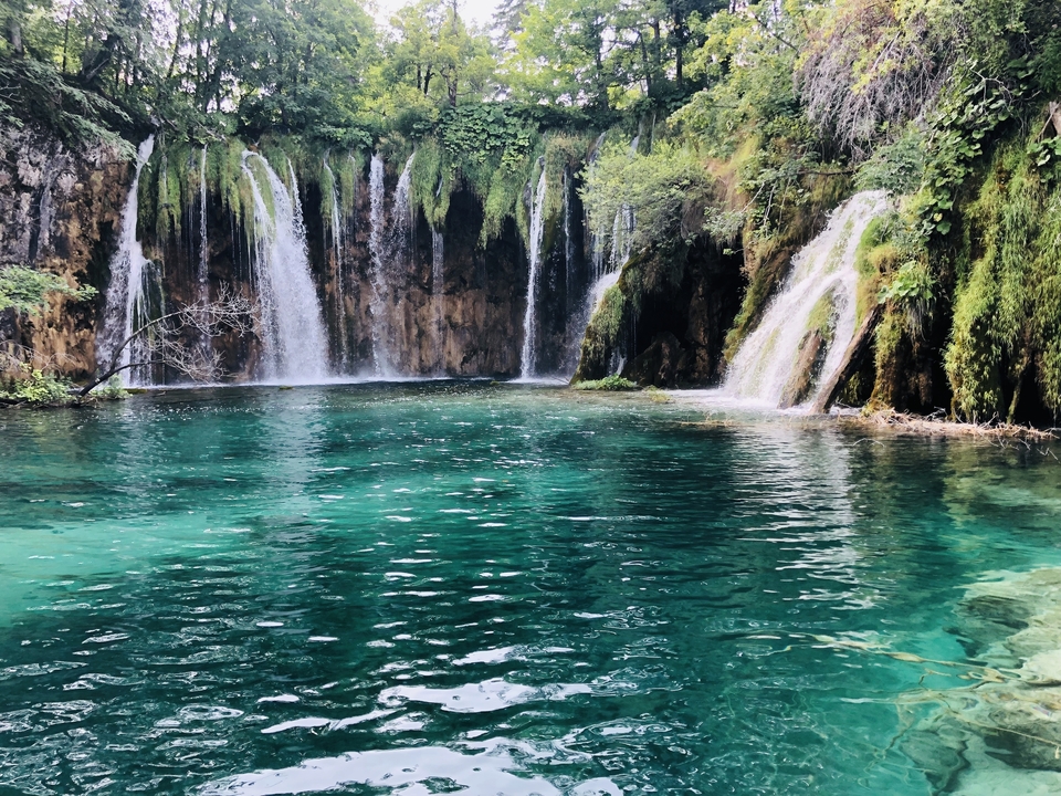 Waterfalls surrounded by lush vegetation at Plitvice Lakes National Park.