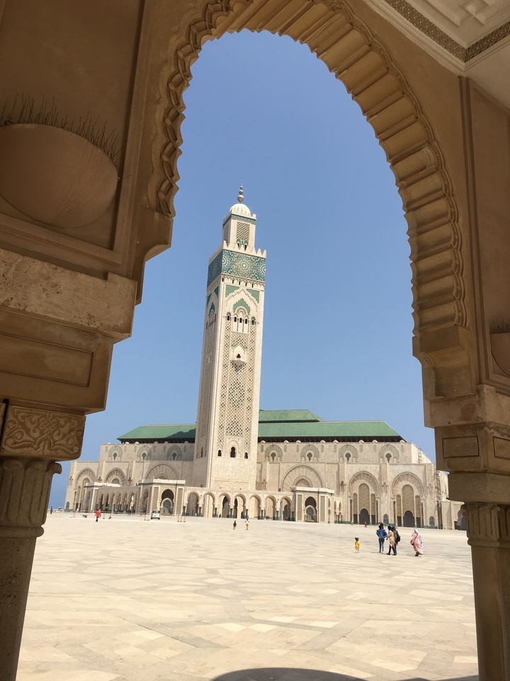 A minaret of a mosque framed by architectural arches.