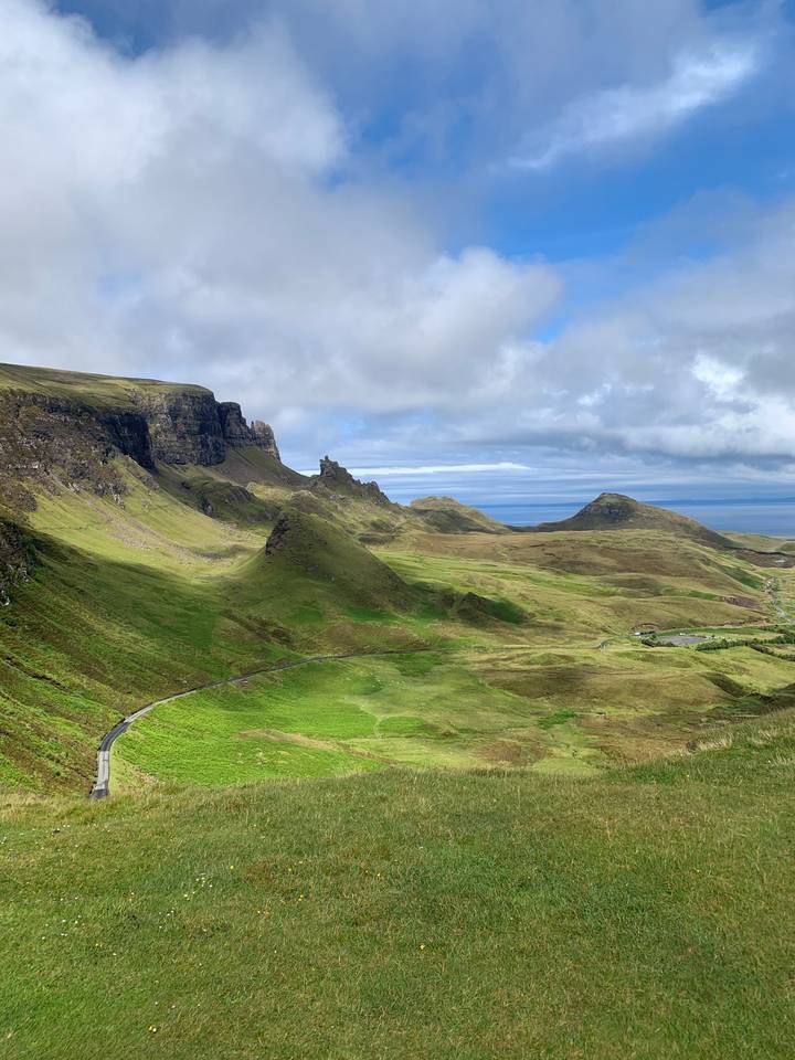 A hilly landscape with green fields under clear skies.
