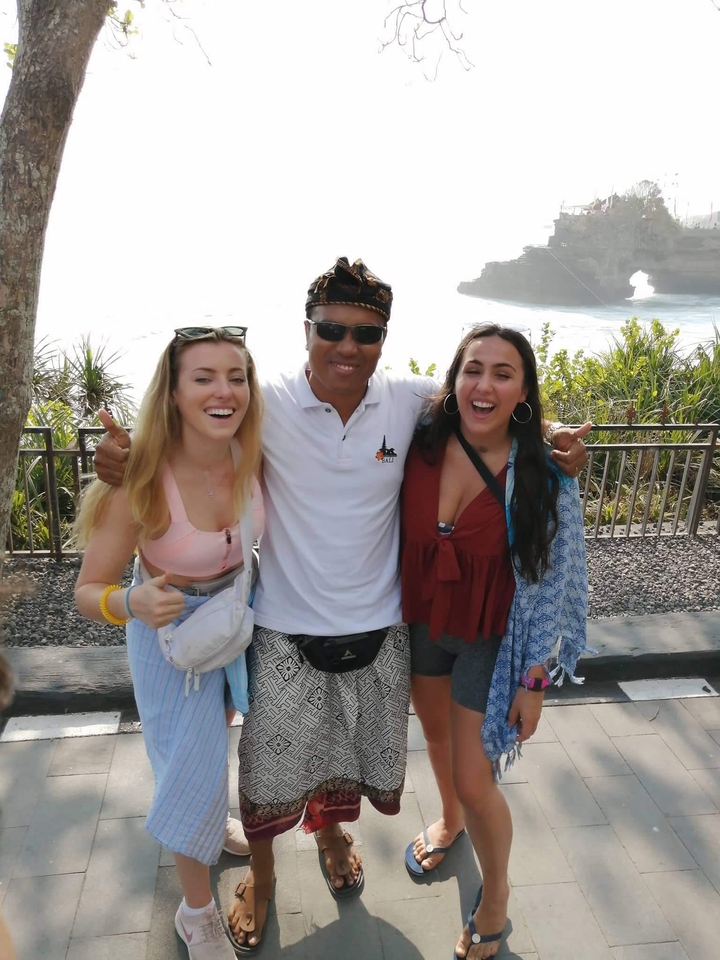 Three friends posing together outdoors.
