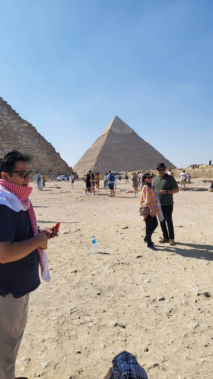 Tourists posing in front of pyramids.