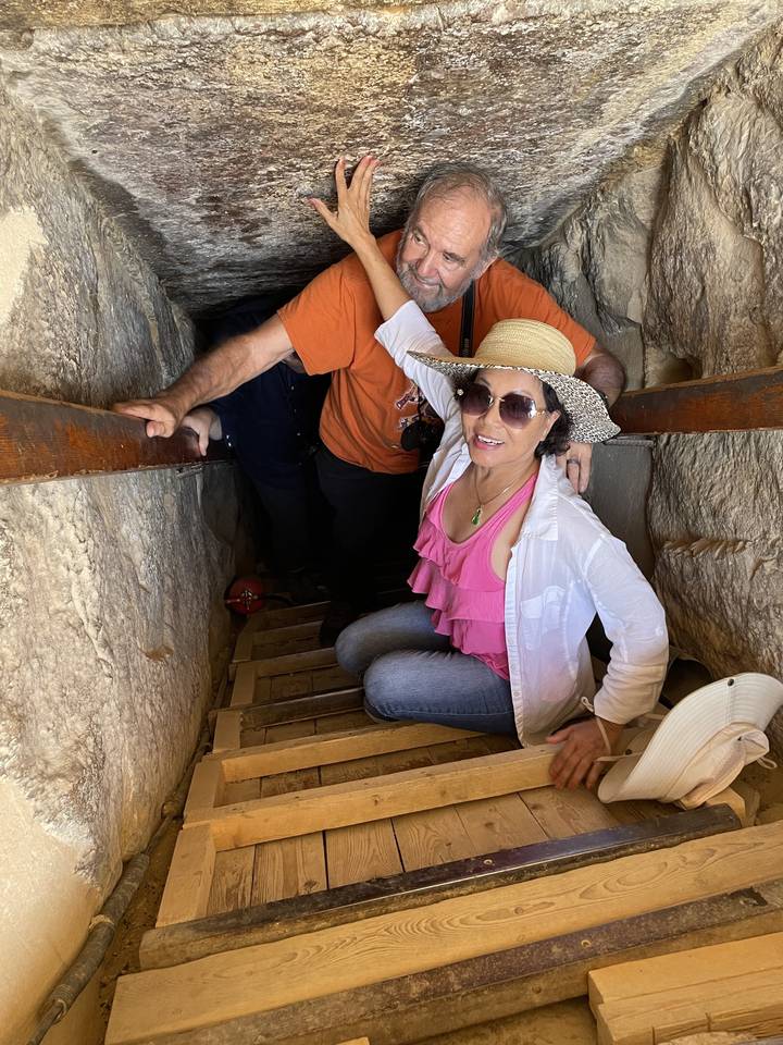 People descending a narrow passageway in a historical site.
