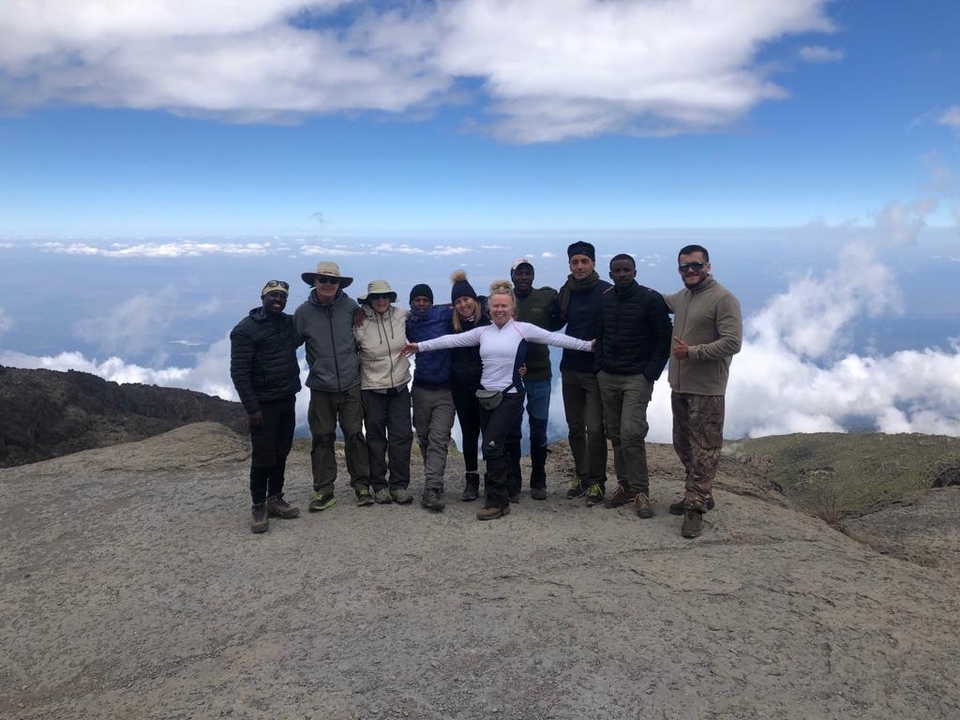 Groupe de randonneurs posant à un point de vue en montagne.