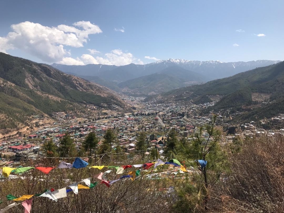 Vue d'une vallée avec une ville et des drapeaux de prière.