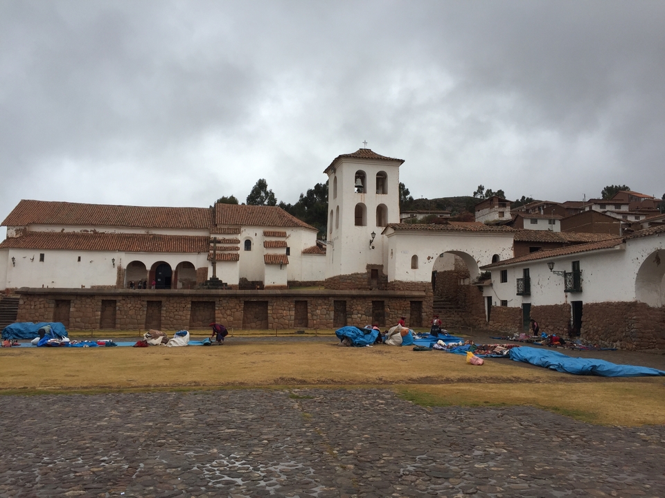 Colonial-style church with people setting up market stalls.