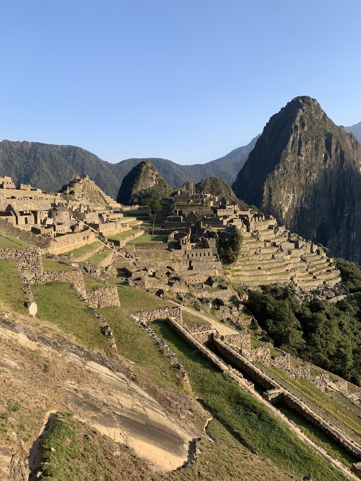 Ruines du Machu Picchu avec terrasses et montagnes en arrière-plan.