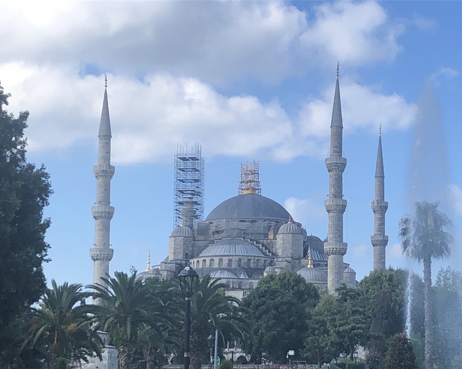 Mosquée historique avec plusieurs minarets et échafaudages.