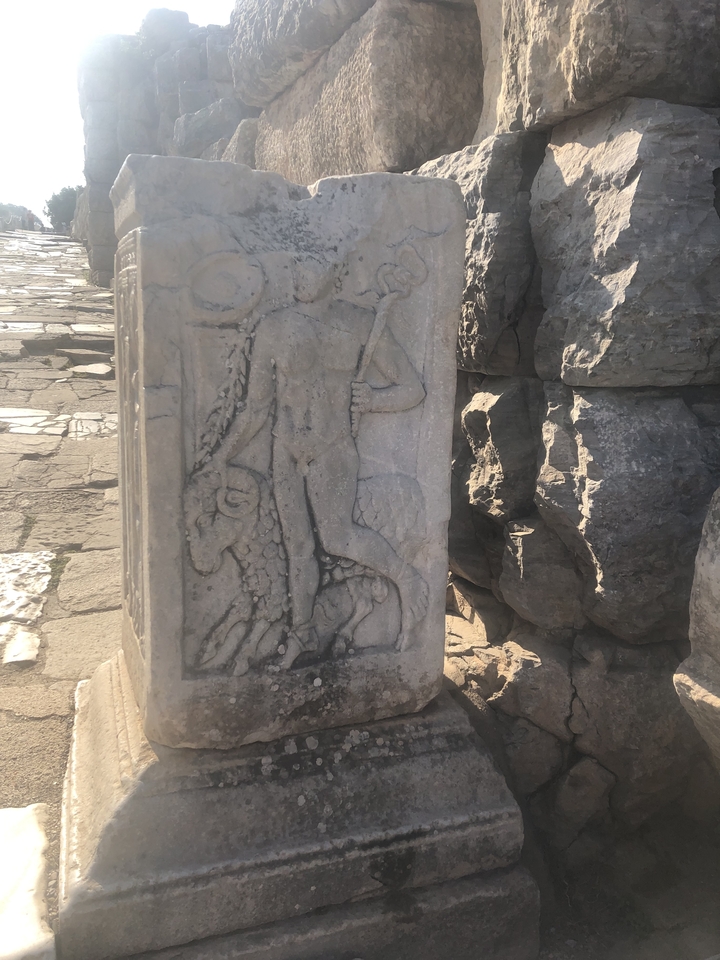 Pierre sculptée ancienne représentant une figure humaine à côté d'un taureau.