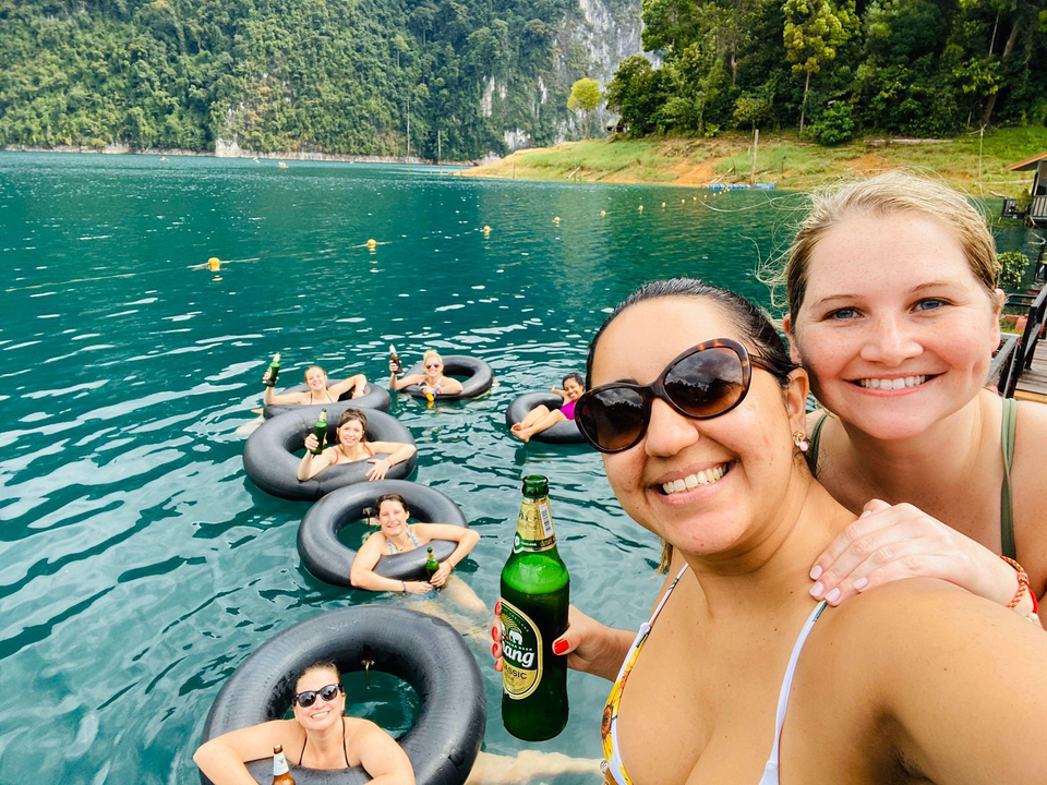 Group of people floating in inner tubes in a lake.