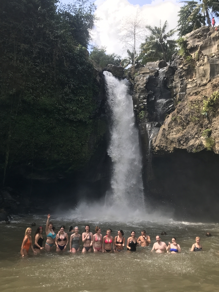 Waterfall cascading down a rocky cliff surrounded by jungle.