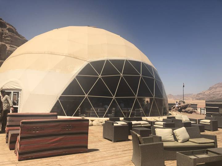 Exterior of a geodesic dome in a desert setting.