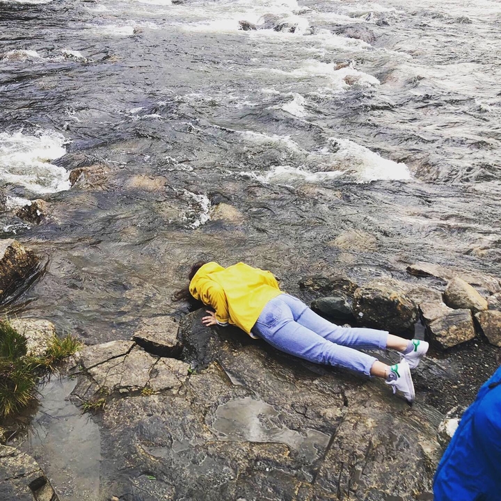 Person drinking water directly from a river.