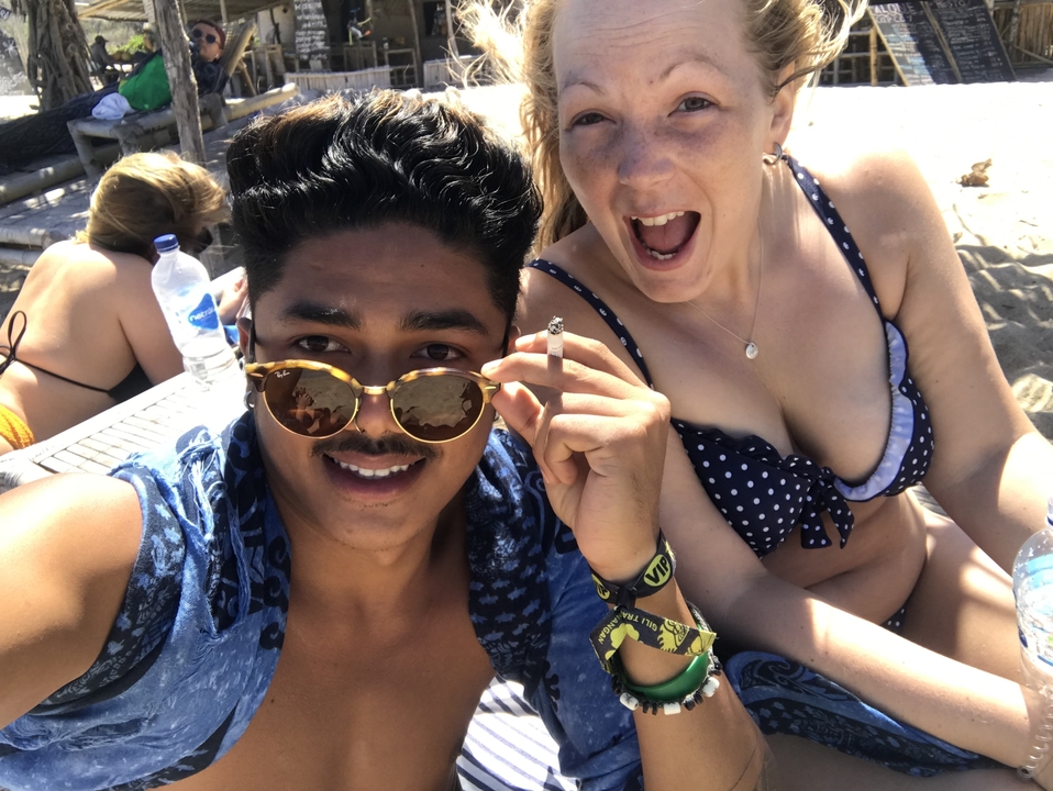 Couple enjoying a day at the beach, smiling at the camera.