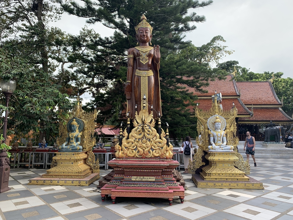Golden and bronze statues on a temple courtyard.