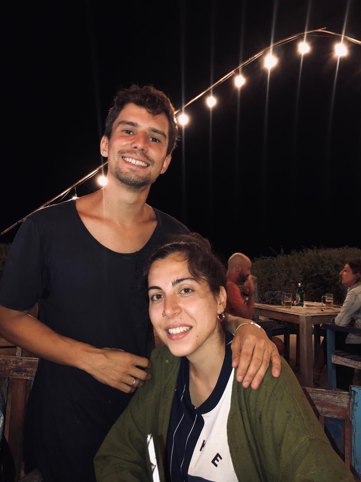 Couple posing at an outdoor restaurant at night.