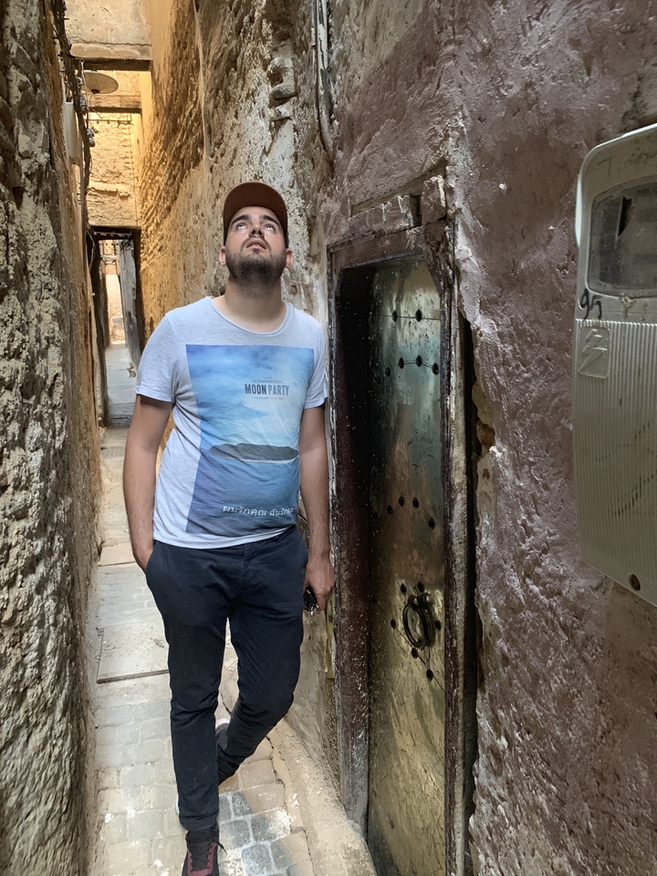 Homme debout dans une ruelle étroite.