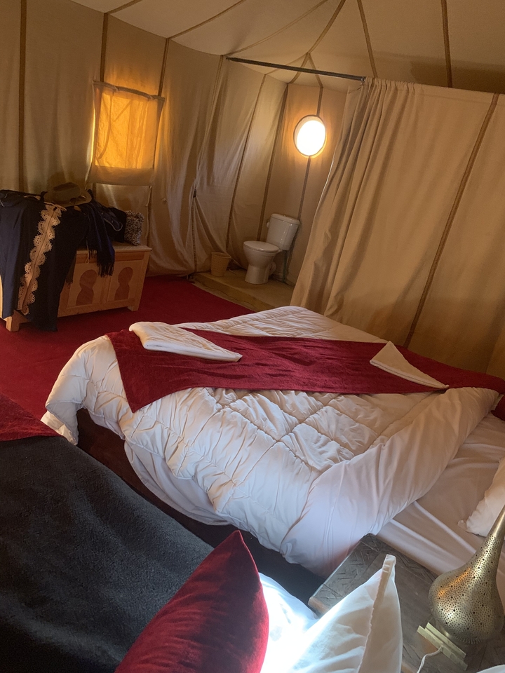 Vue intérieure d'une tente avec un lit et une salle de bain.