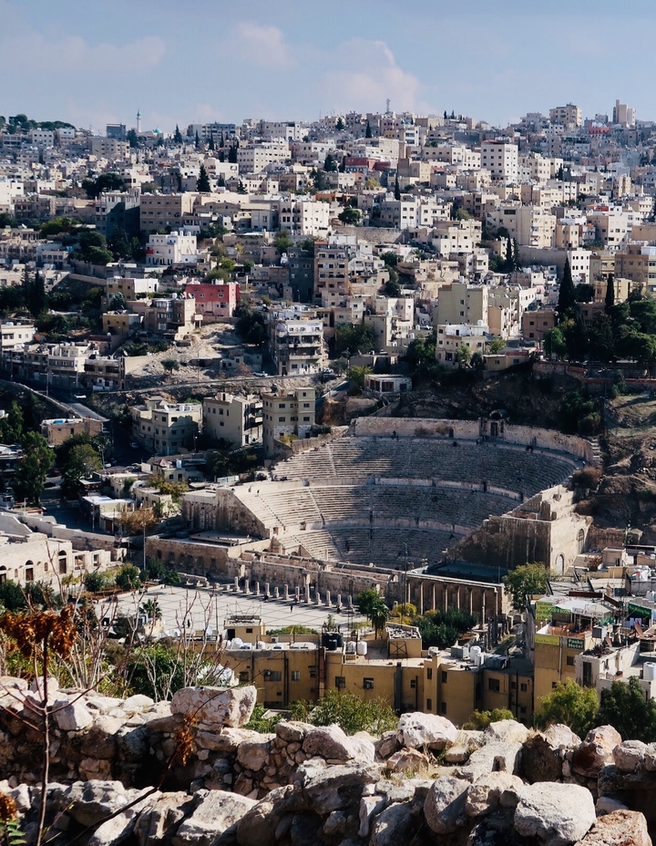 Amphithéâtre au milieu de bâtiments urbains dans un cadre historique.