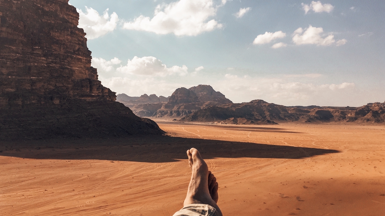 Vue panoramique d'un paysage désertique avec des empreintes de pas dans le sable.
