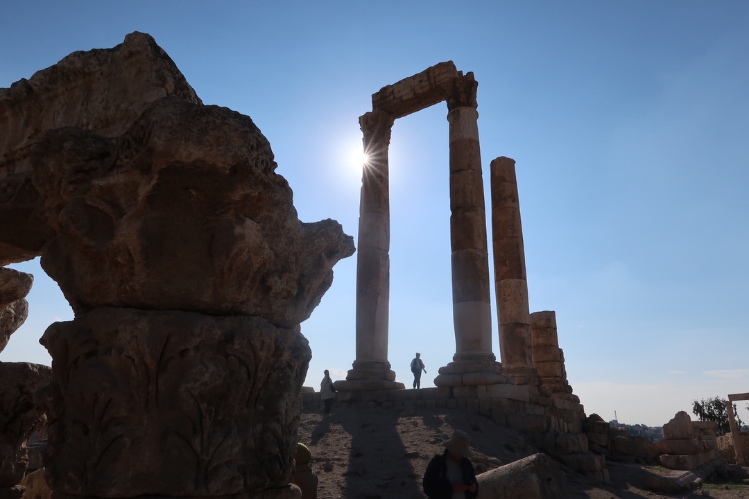 "Majestueuses colonnes se détachant contre le soleil avec un premier plan rocheux."