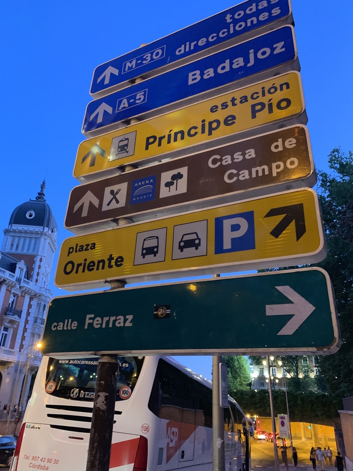 Multiple street signs with directional icons and indications.