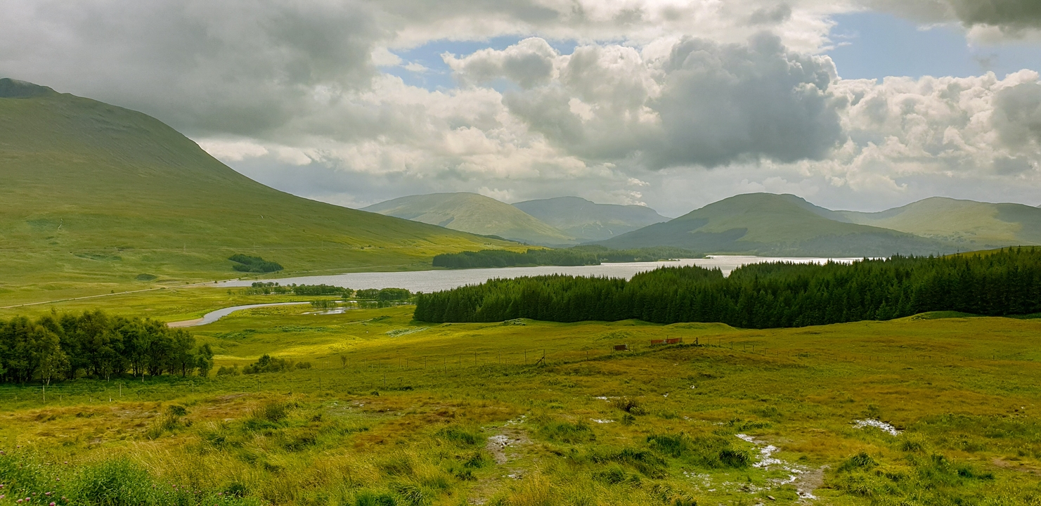 A scenic view of rolling hills and a distant lake.