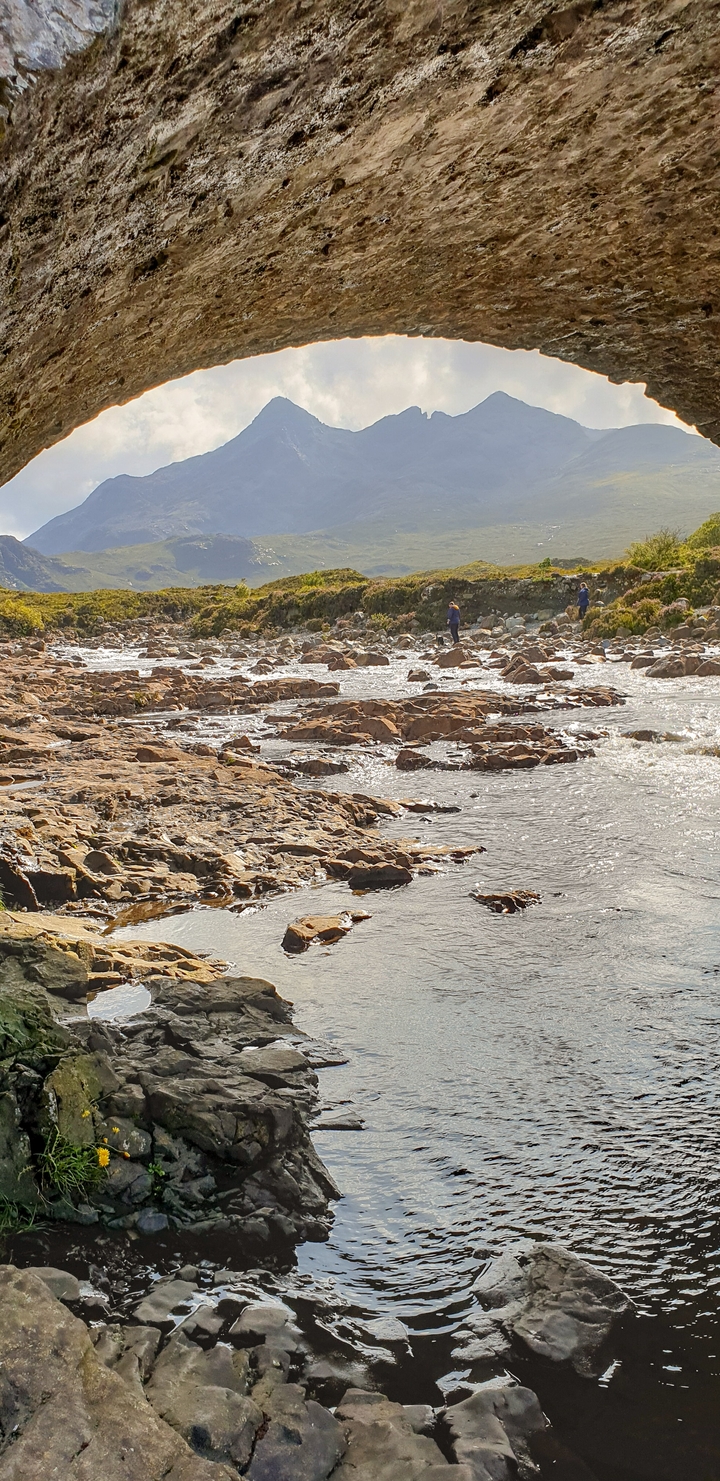 People exploring a rocky riverbed.