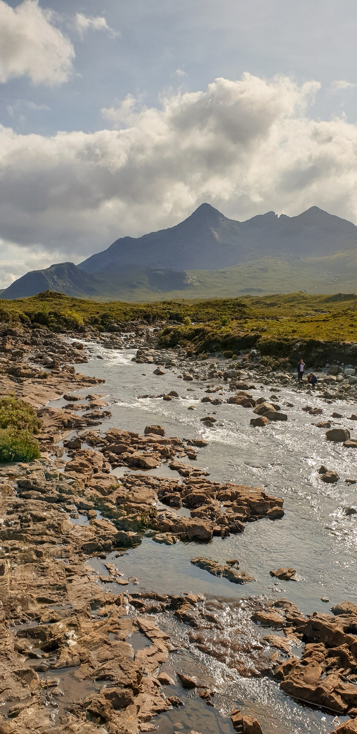 People exploring a rocky riverbed.