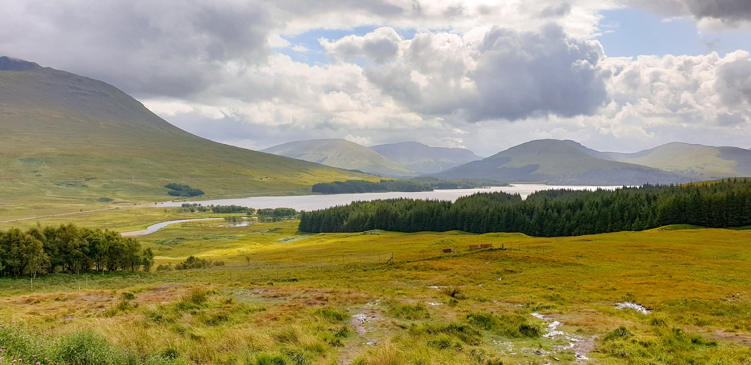 A scenic view of rolling hills and a distant lake.