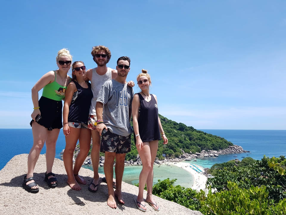 Group of friends on a hill with a view of the ocean.