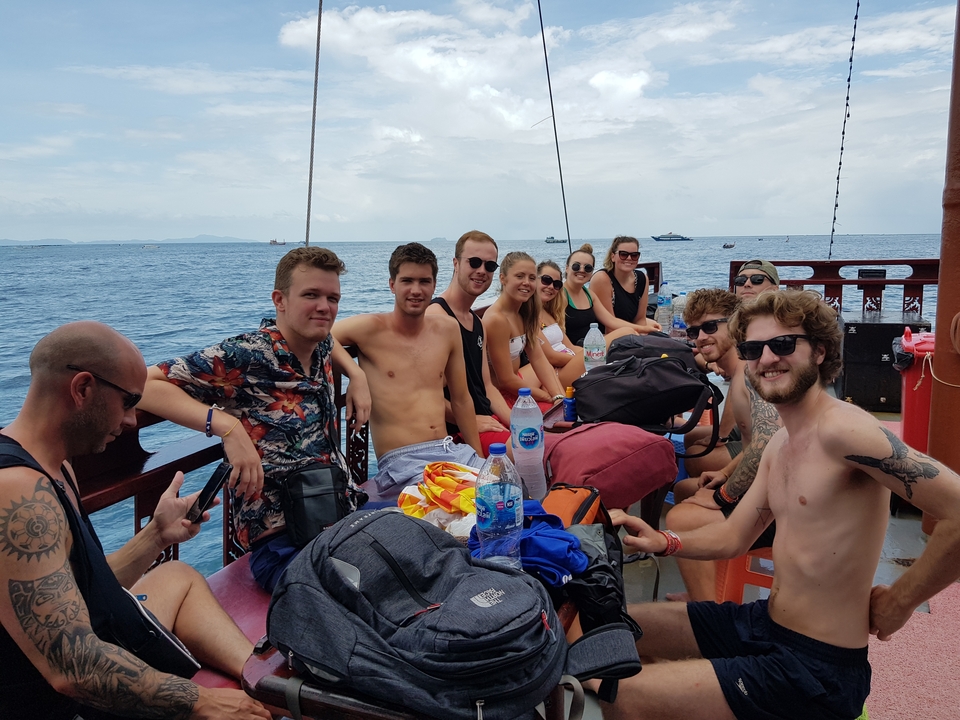Group relaxing on a boat with blue waters.