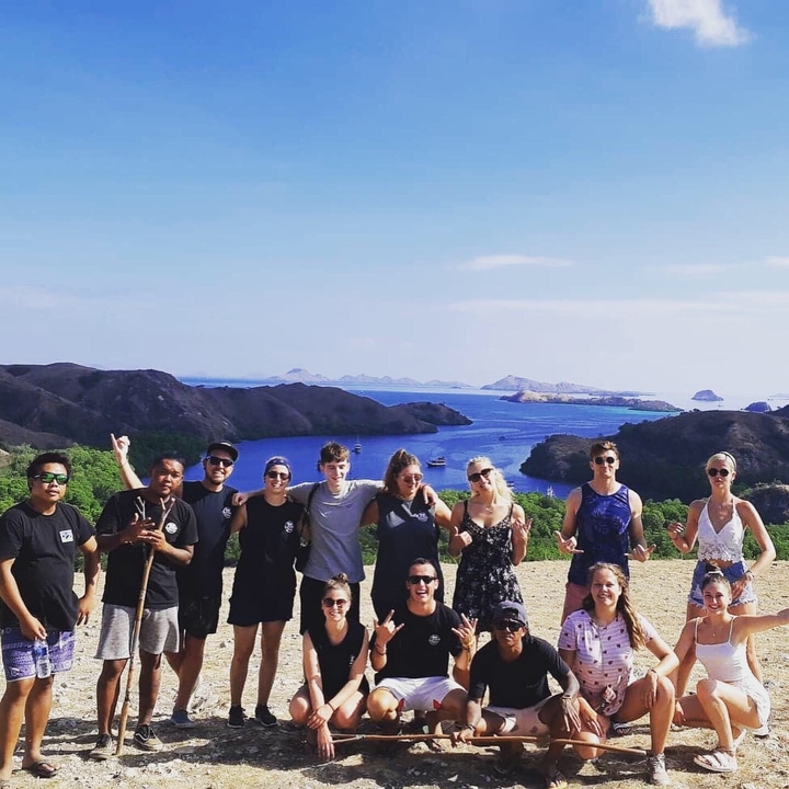 Group of people posing with a scenic water background